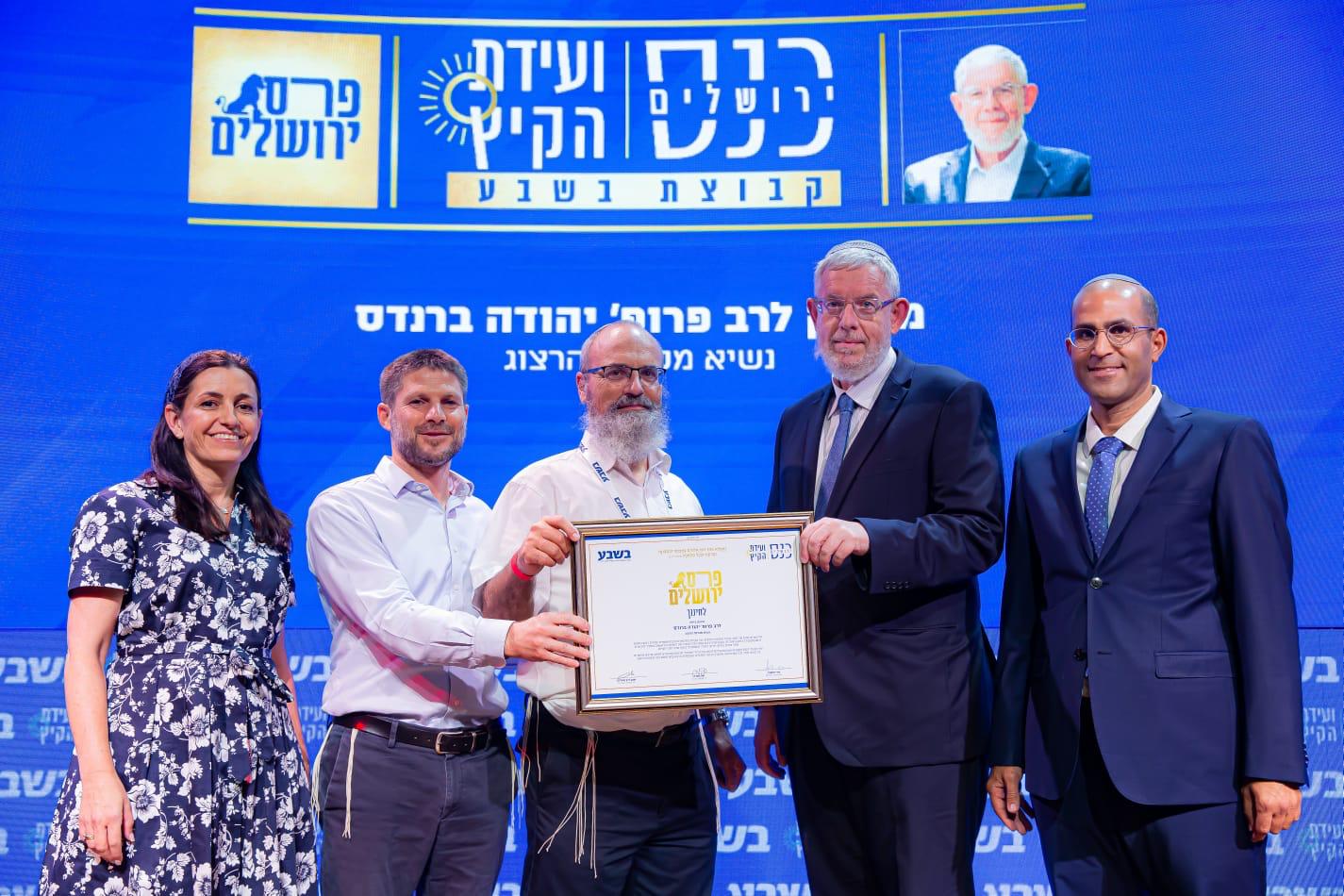 Rabbi Dr. Yehuda Brandes receives his prize from Dudi Finkler and Emanuel Shilo from B'Sheva and MK Betzalel Smotrich. 